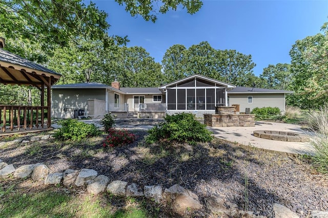 21509 Rockwell Dr, Lebanon, MO 65536 - rear view of property featuring a sunroom, an outdoor fire pit, a gazebo, a patio, and a deck