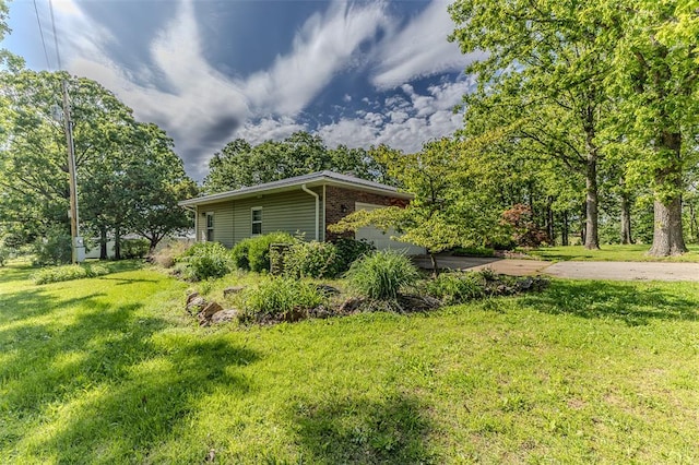 21509 Rockwell Dr, Lebanon, MO 65536 - view of side of home featuring a lawn and brick siding