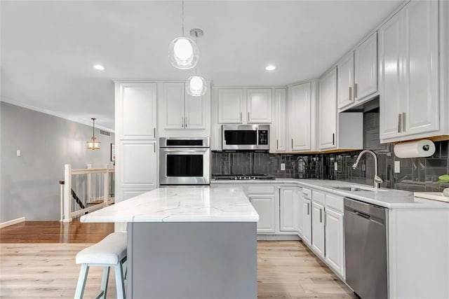 402 Glan Tai Dr, Manchester, MO 63011 - kitchen featuring appliances with stainless steel finishes, a sink, tasteful backsplash, white cabinets, and ornamental molding