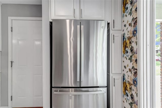402 Glan Tai Dr, Manchester, MO 63011 - kitchen featuring freestanding refrigerator, white cabinetry, and wallpapered walls