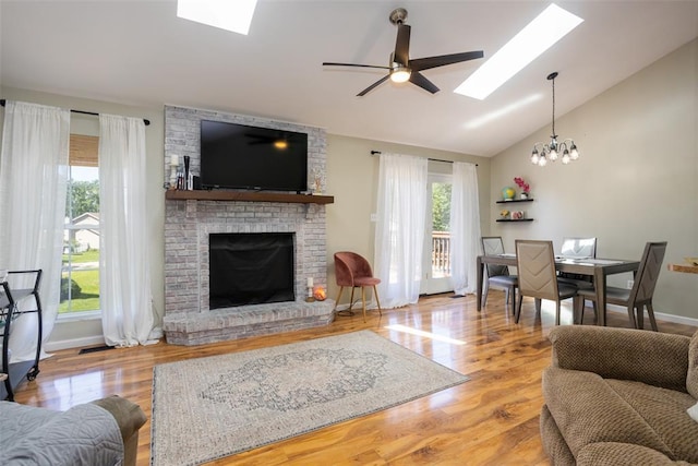 4 Aken Ct, Saint Peters, MO 63376 - living room featuring a skylight, a brick fireplace, lofted ceiling, a ceiling fan, and a chandelier