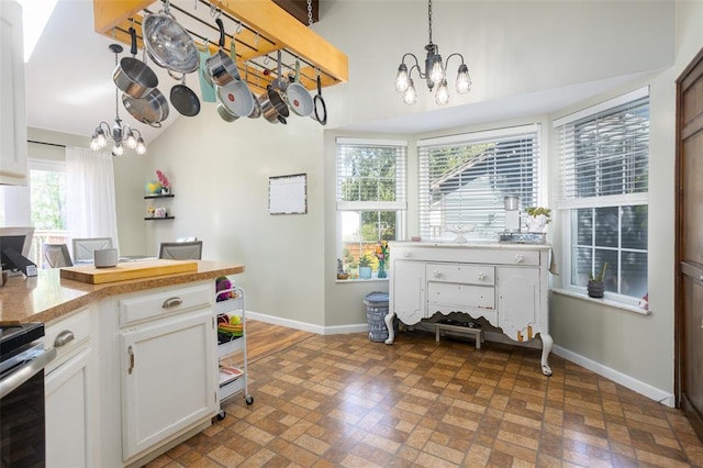 4 Aken Ct, Saint Peters, MO 63376 - kitchen with a chandelier, baseboards, brick patterned floors, and stainless steel range with electric stovetop