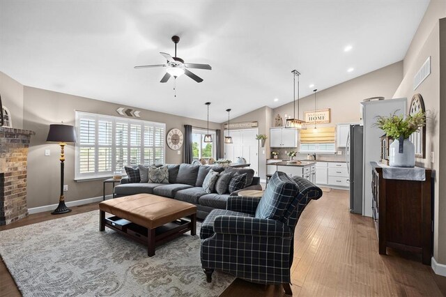 536 W 5th St, Saint Jacob, IL 62281 - living room with ceiling fan, lofted ceiling, light wood finished floors, a brick fireplace, and baseboards