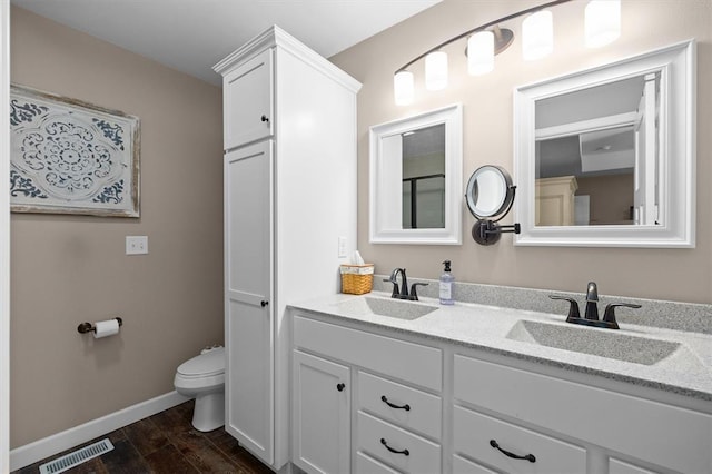 536 W 5th St, Saint Jacob, IL 62281 - bathroom with wood finished floors, toilet, double vanity, and baseboards