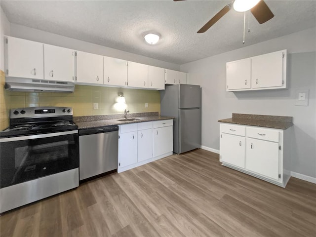 2540 Courtyard Pl, Florissant, MO 63031 - kitchen with appliances with stainless steel finishes, under cabinet range hood, a sink, white cabinets, and a textured ceiling