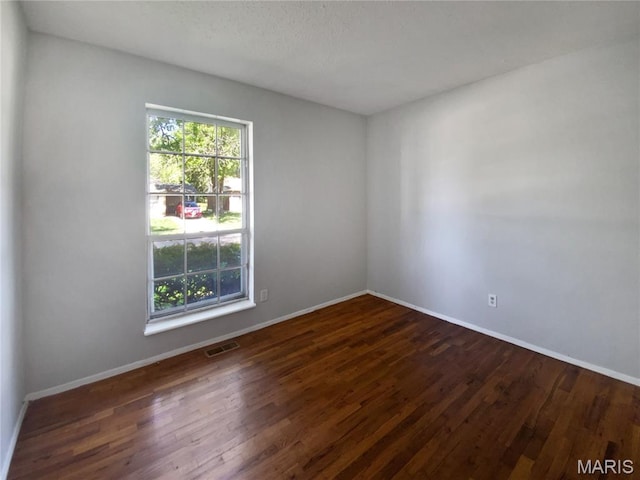 2540 Courtyard Pl, Florissant, MO 63031 - spare room featuring dark wood-style flooring and baseboards