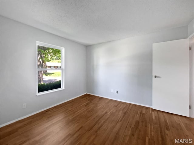 2540 Courtyard Pl, Florissant, MO 63031 - unfurnished room with wood finished floors, baseboards, and a textured ceiling
