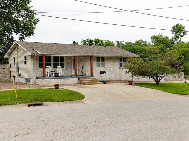 3930 Commanche Ave, Hannibal, MO 63401 - ranch-style house featuring covered porch, brick siding, a front lawn, and roof with shingles