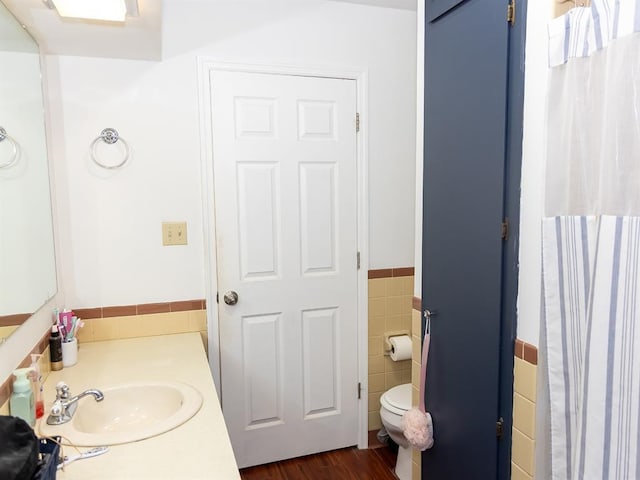 3930 Commanche Ave, Hannibal, MO 63401 - bathroom with tile walls, vanity, toilet, wainscoting, and wood finished floors