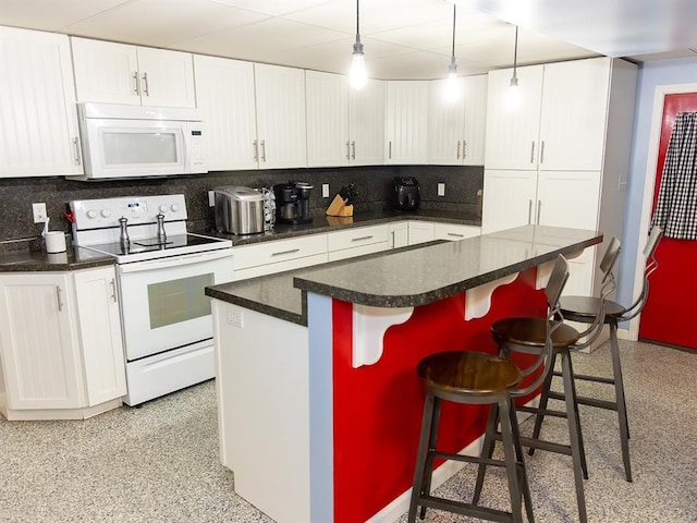 3930 Commanche Ave, Hannibal, MO 63401 - kitchen featuring white appliances, tasteful backsplash, a kitchen island, and white cabinets