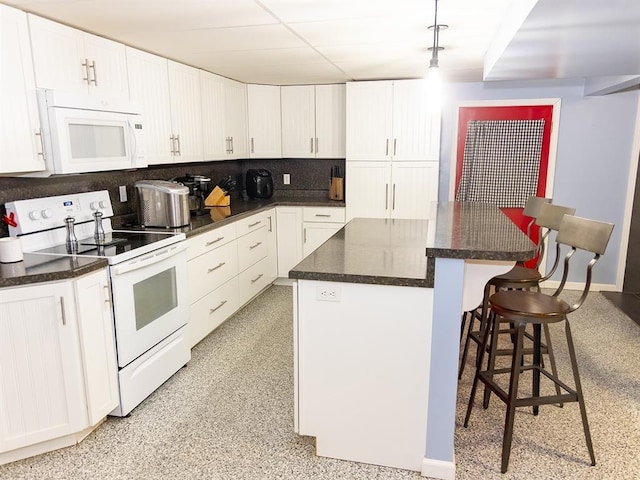 3930 Commanche Ave, Hannibal, MO 63401 - kitchen featuring white appliances, white cabinetry, a center island, and a breakfast bar