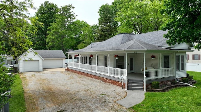 view of front of house featuring a porch, an outdoor structure, a detached garage, a front yard, and a shingled roof