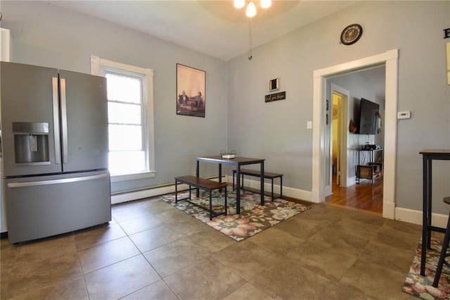 dining room with a baseboard radiator, tile patterned floors, and baseboards