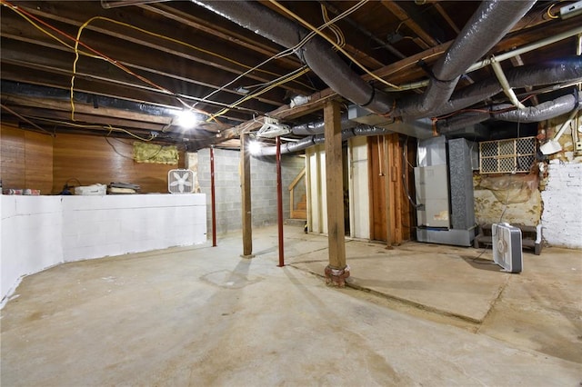 unfinished basement with heating unit and stairway