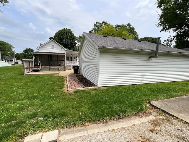 exterior space featuring a yard, a porch, and roof with shingles