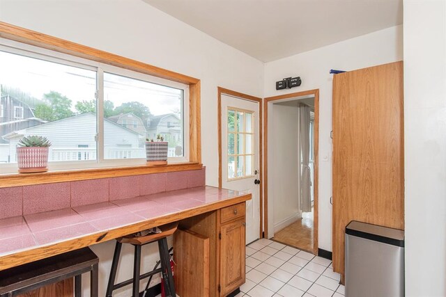 5156 Christy Ave, Saint Louis, MO 63116 - kitchen featuring tile countertops, healthy amount of natural light, and light tile patterned flooring