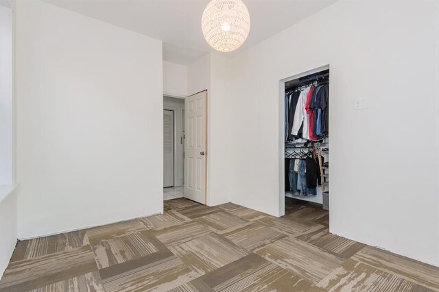 5156 Christy Ave, Saint Louis, MO 63116 - unfurnished bedroom featuring a chandelier, a spacious closet, and a closet