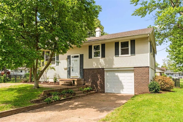raised ranch featuring brick siding, an attached garage, driveway, and a chimney