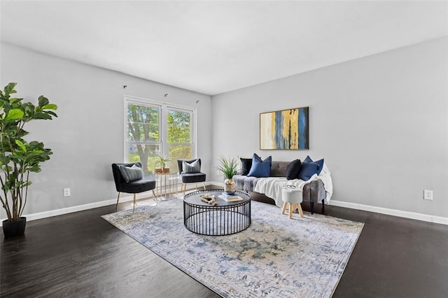 living room with dark wood-type flooring and baseboards