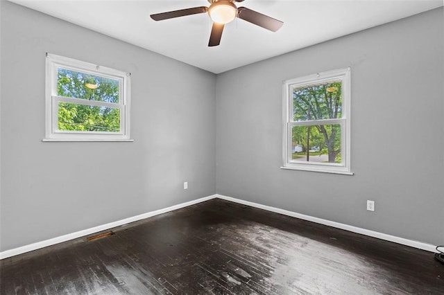 unfurnished room featuring baseboards, hardwood / wood-style floors, and a ceiling fan