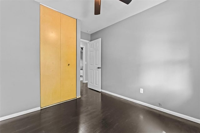 unfurnished bedroom featuring baseboards, wood finished floors, and ceiling fan