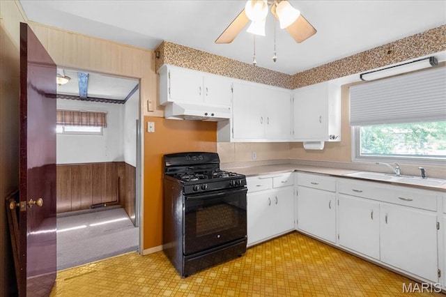 1816 N Belt, Belleville, IL 62221 - kitchen featuring black range with gas stovetop, range hood, plenty of natural light, light flooring, and wooden walls