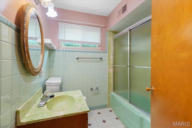 1816 N Belt, Belleville, IL 62221 - bathroom with tile walls, tile patterned flooring, vanity, and combined bath / shower with glass door