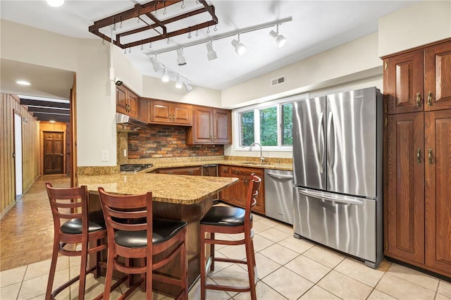 9216 Matthews Ln, Sunset Hills, MO 63127 - kitchen featuring stainless steel appliances, a sink, a peninsula, a breakfast bar, and tasteful backsplash