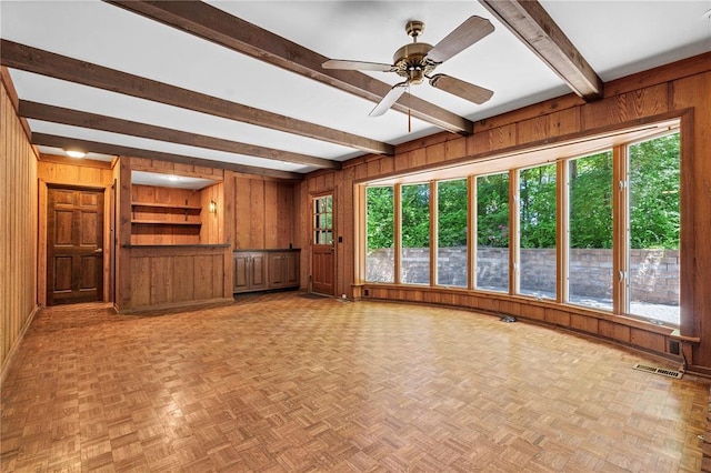 9216 Matthews Ln, Sunset Hills, MO 63127 - unfurnished living room featuring wood walls, beam ceiling, ceiling fan, and healthy amount of natural light