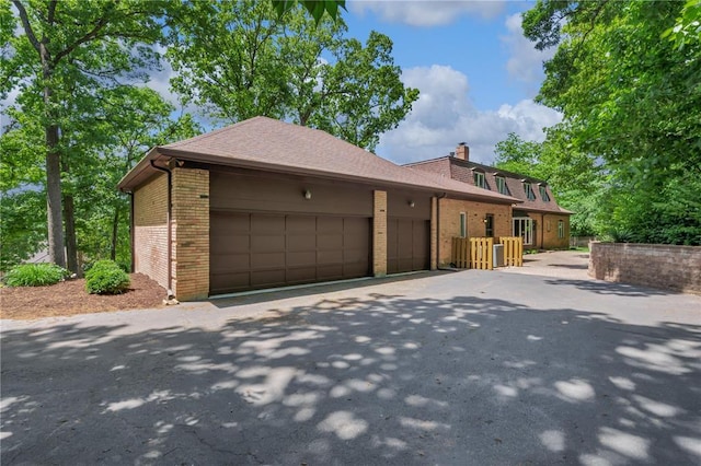 9216 Matthews Ln, Sunset Hills, MO 63127 - view of front of home featuring brick siding, a garage, a chimney, and driveway