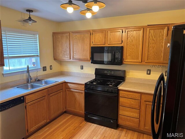 2828 Rutger St, Saint Louis, MO 63104 - kitchen with black appliances, a sink, light countertops, light wood-type flooring, and brown cabinets