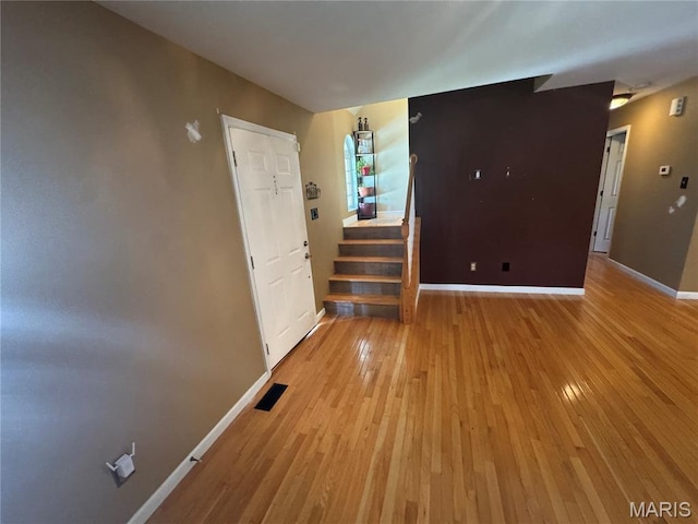 2828 Rutger St, Saint Louis, MO 63104 - empty room with light wood finished floors, baseboards, and stairs