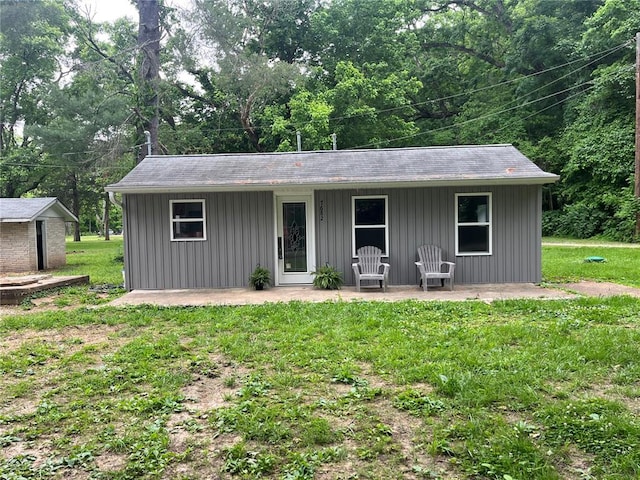 view of front facade with board and batten siding and a front yard