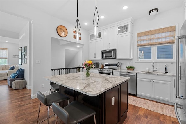 1017 Kilderkin Way, Saint Charles, MO 63301 - kitchen with stainless steel appliances, a sink, a center island, a kitchen bar, and light stone countertops