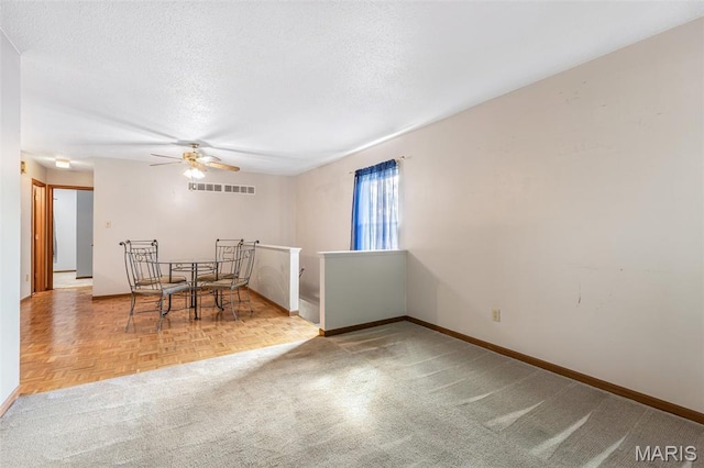101 Carnegie Ct, Valley Park, MO 63088 - unfurnished dining area featuring ceiling fan, baseboards, a textured ceiling, and carpet
