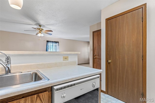 101 Carnegie Ct, Valley Park, MO 63088 - kitchen with dishwasher, a sink, brown cabinetry, light countertops, and a textured ceiling