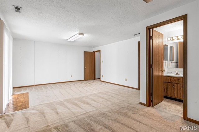 101 Carnegie Ct, Valley Park, MO 63088 - spare room with a textured ceiling, light carpet, baseboards, and a sink