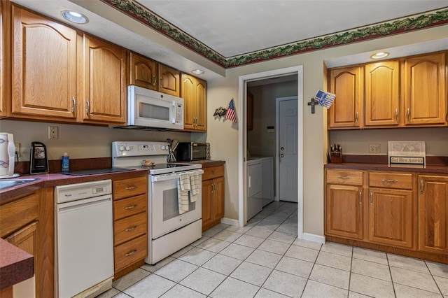 303 Holly Tree Ln, Farmington, MO 63640 - kitchen featuring white appliances, dark countertops, light tile patterned floors, brown cabinets, and recessed lighting