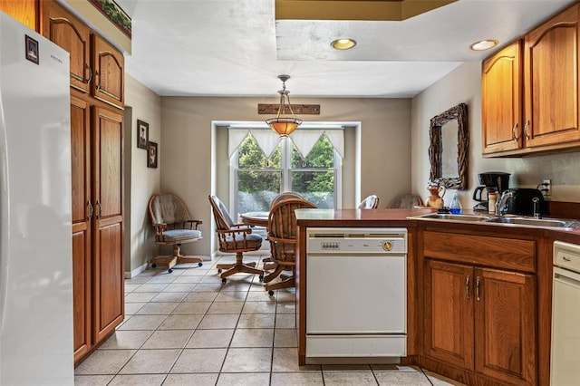 303 Holly Tree Ln, Farmington, MO 63640 - kitchen with white appliances, a sink, brown cabinetry, a peninsula, and light tile patterned floors