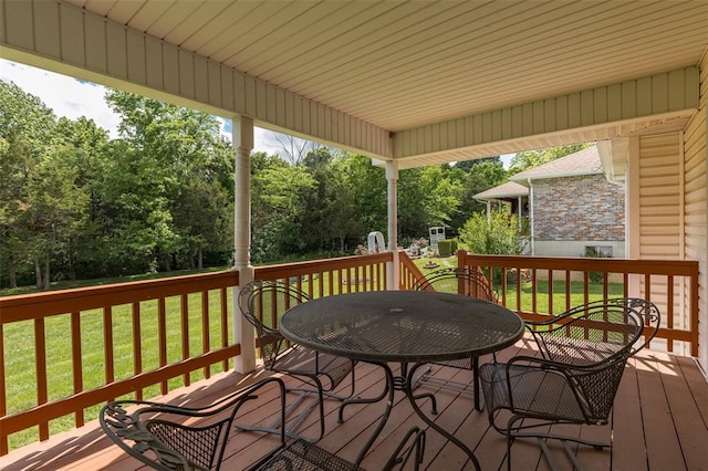 303 Holly Tree Ln, Farmington, MO 63640 - wooden deck with outdoor dining area, a lawn, and view of scattered trees