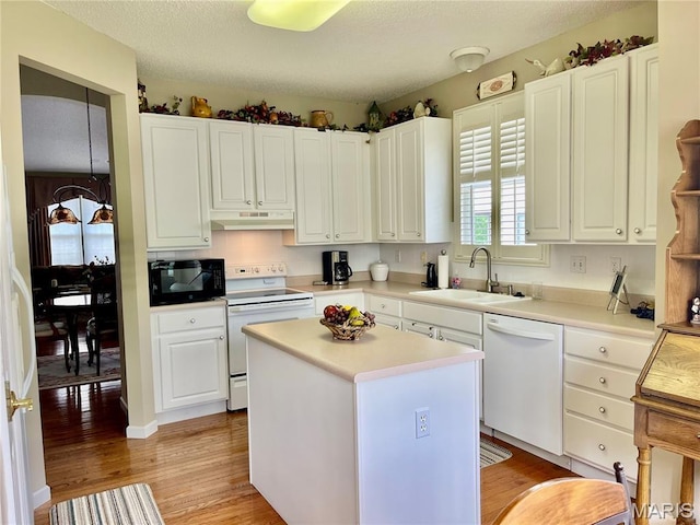 2087 Hawks Landing Dr, Lake St Louis, MO 63367 - kitchen with white appliances, under cabinet range hood, light wood-type flooring, white cabinets, and light countertops