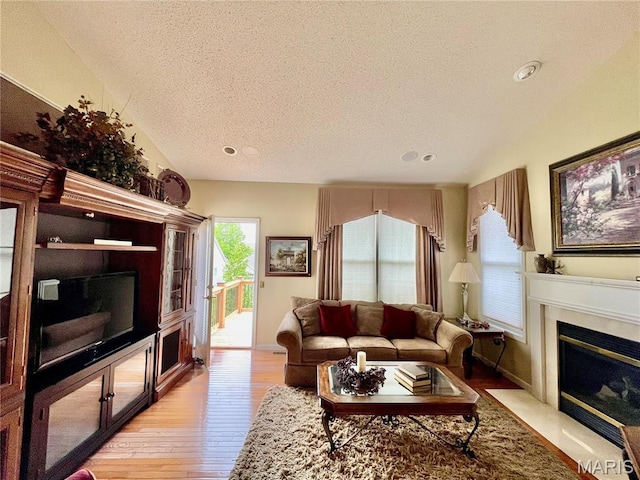 2087 Hawks Landing Dr, Lake St Louis, MO 63367 - living room featuring a textured ceiling, light wood-type flooring, a high end fireplace, and recessed lighting