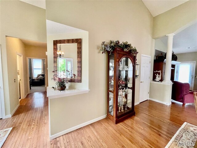 2087 Hawks Landing Dr, Lake St Louis, MO 63367 - foyer entrance featuring wood finished floors, decorative columns, plenty of natural light, a chandelier, and high vaulted ceiling