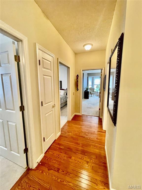 2087 Hawks Landing Dr, Lake St Louis, MO 63367 - hall featuring wood finished floors and a textured ceiling