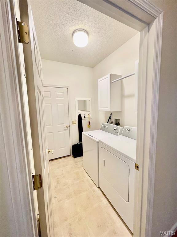 2087 Hawks Landing Dr, Lake St Louis, MO 63367 - washroom featuring washer and dryer and a textured ceiling