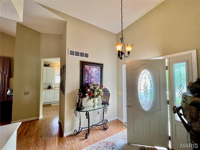 2087 Hawks Landing Dr, Lake St Louis, MO 63367 - entryway with high vaulted ceiling, a chandelier, and light wood-type flooring