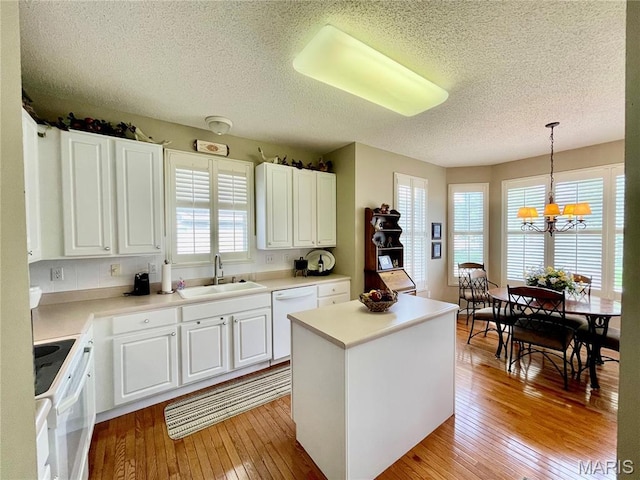 2087 Hawks Landing Dr, Lake St Louis, MO 63367 - kitchen with white appliances, light wood-style floors, a textured ceiling, a chandelier, and a kitchen island