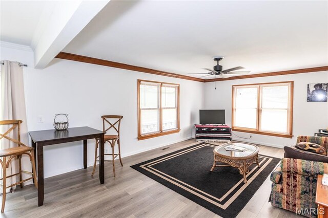 2915 Ozark Dr, Queeny Township, MO 63122 - living area featuring wood finished floors, healthy amount of natural light, crown molding, ceiling fan, and baseboards