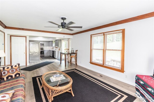 2915 Ozark Dr, Queeny Township, MO 63122 - living area featuring crown molding, wood finished floors, a ceiling fan, and baseboards