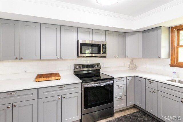 2915 Ozark Dr, Queeny Township, MO 63122 - kitchen with stainless steel appliances, gray cabinetry, backsplash, and ornamental molding